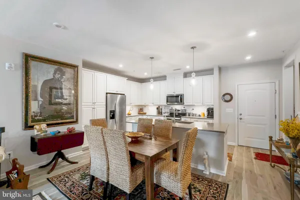 a kitchen with cabinets a refrigerator and a dining table