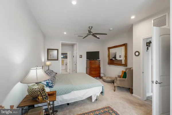 a spacious bedroom with a bed and a chandelier