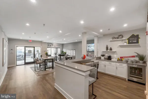 a kitchen view with wooden floor and stainless steel appliances
