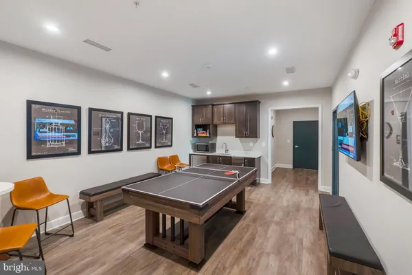 a living room with stainless steel appliances kitchen island a table and chairs in it