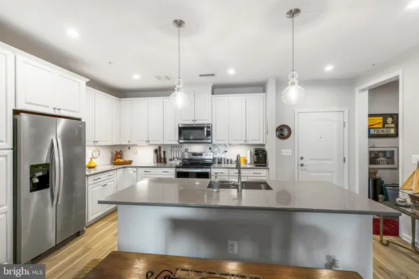 a kitchen with stainless steel appliances granite countertop a refrigerator a sink and a stove