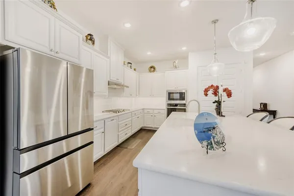 a kitchen with stainless steel appliances granite countertop a refrigerator sink and cabinets