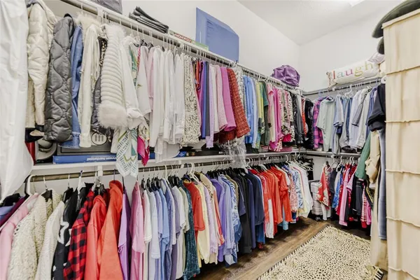 a view of walk in closet with clothes