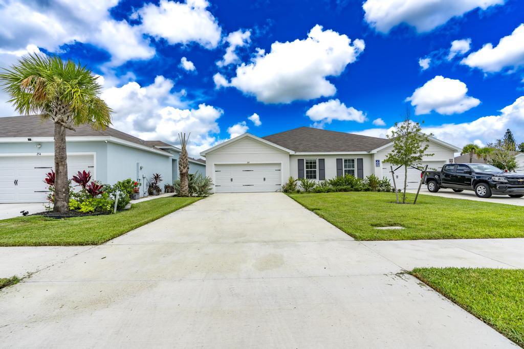 252 Raspberry Road Fort Pierce, FL 34981 - Photo 4 of 66 a front view of a house with a garden and trees