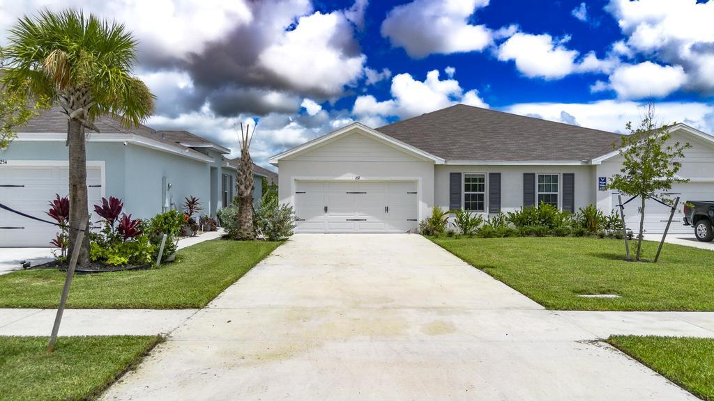 252 Raspberry Road Fort Pierce, FL 34981 - Photo 66 of 66 a front view of a house with a yard and a garage