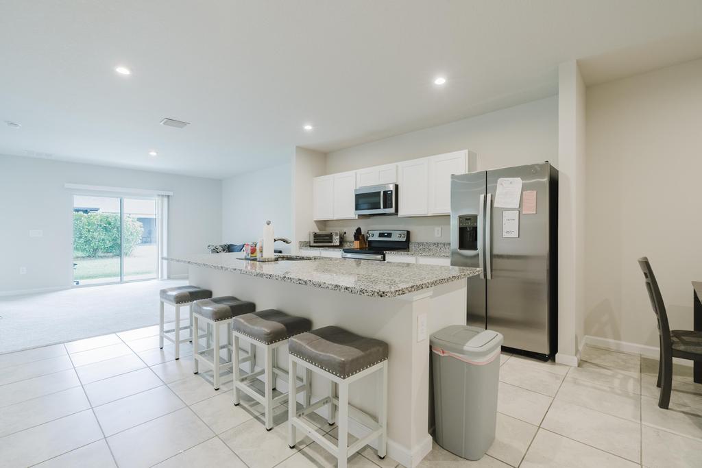 252 Raspberry Road Fort Pierce, FL 34981 - Photo 7 of 66 a kitchen with stainless steel appliances a refrigerator a stove a sink a dining table and chairs