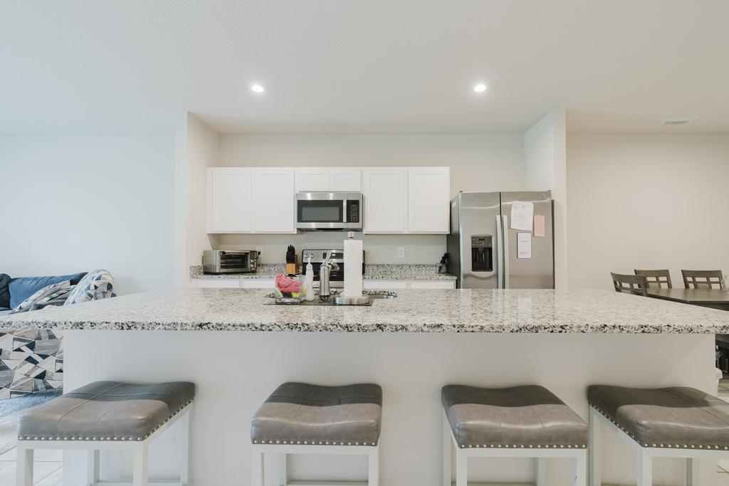 252 Raspberry Road Fort Pierce, FL 34981 - Photo 8 of 66 a kitchen with stainless steel appliances granite countertop a sink a stove a microwave a refrigerator and white cabinets