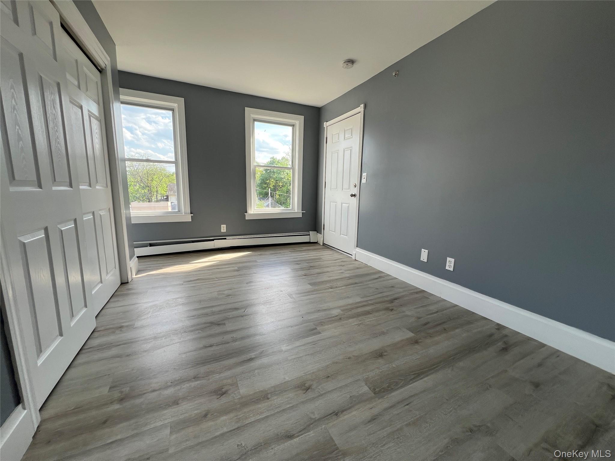 761 Main Street, Unit 3E Poughkeepsie, NY 12603 - Photo 7 of 8 a view of an empty room with wooden floor and a window