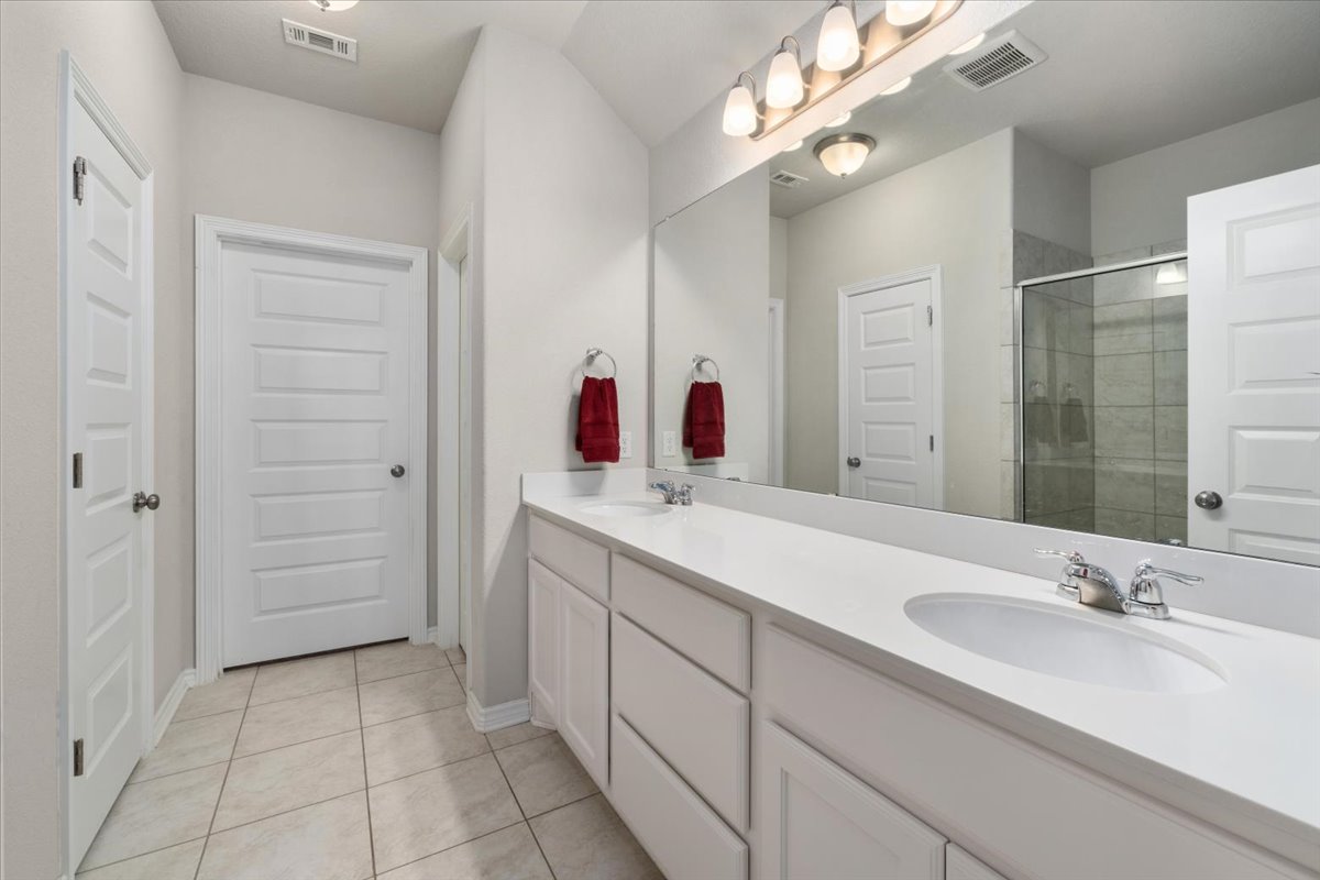 5408 Vanner Path Georgetown, TX 78626 - Photo 19 of 34 Double vanity with white cabinetry and integrated sinks