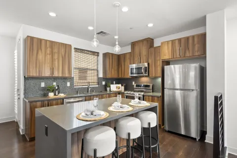 a kitchen with refrigerator a sink and chairs