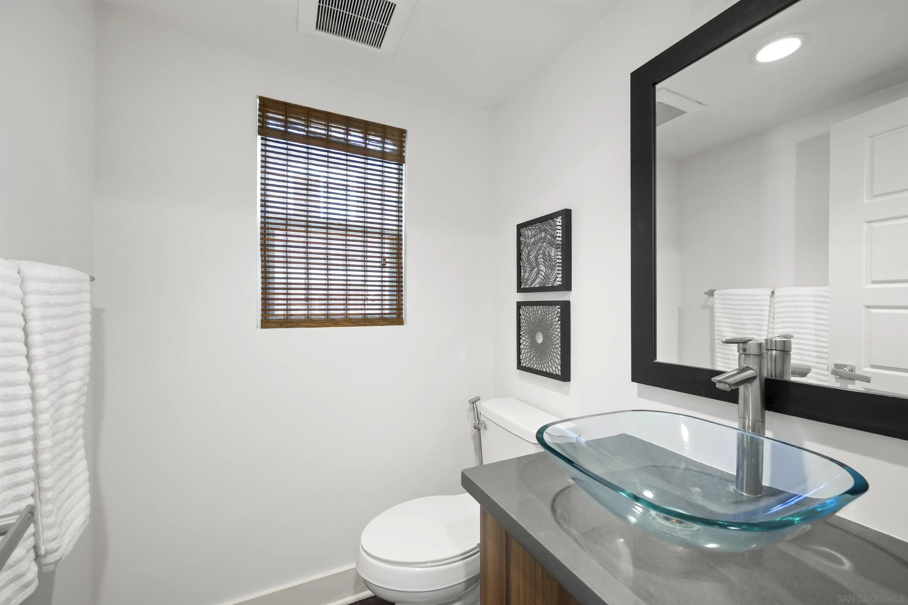 7853 Inception Way San Diego, CA 92108 - Photo 25 of 66 a bathroom with a toilet a sink and mirror