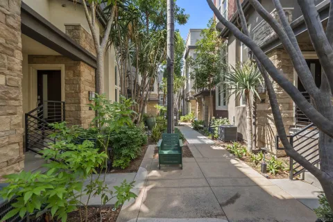 a kitchen with stainless steel appliances granite countertop a dining table chairs refrigerator and microwave