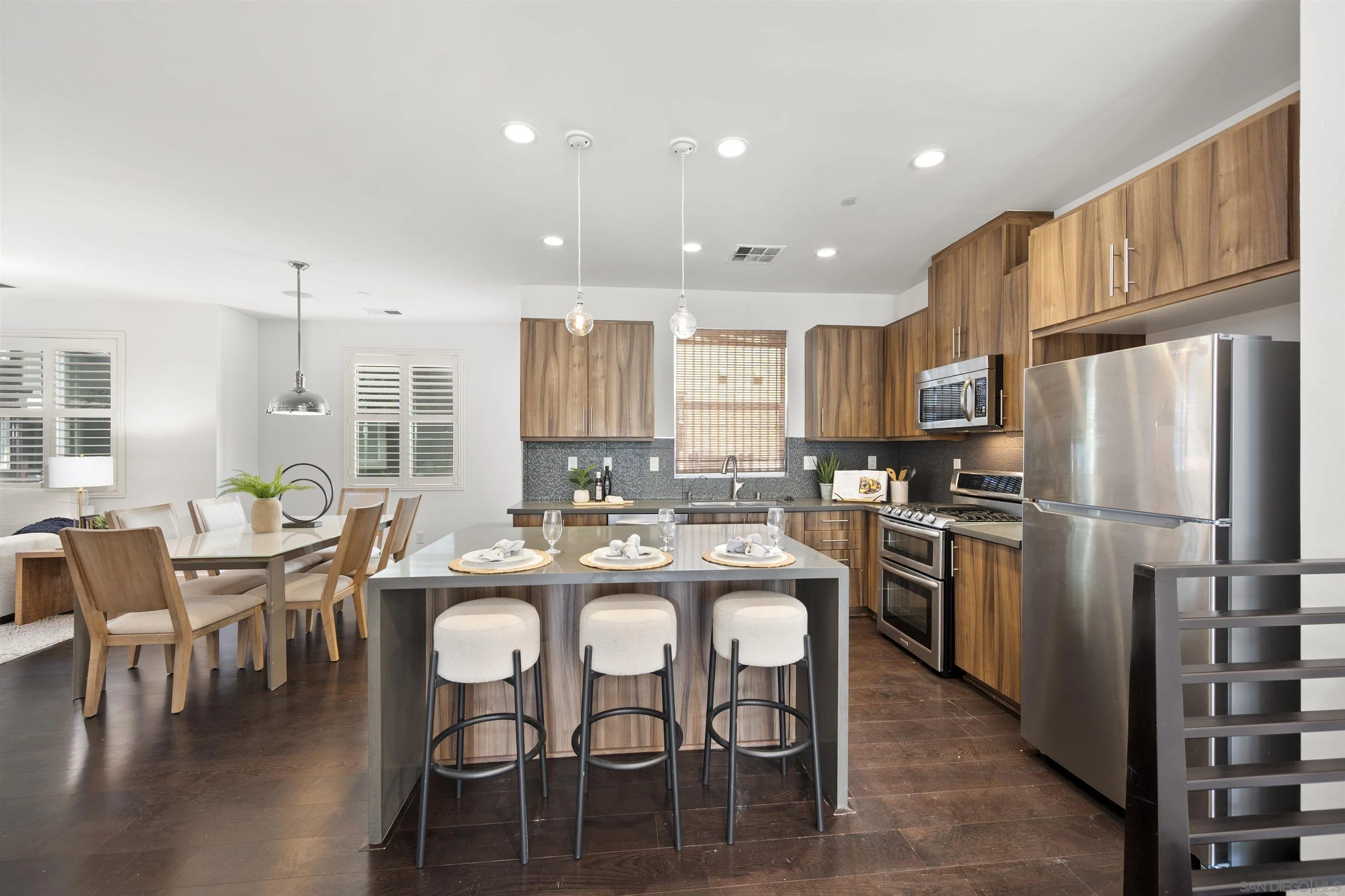 7853 Inception Way San Diego, CA 92108 - Photo 5 of 66 a kitchen with stainless steel appliances granite countertop a dining table chairs refrigerator and microwave