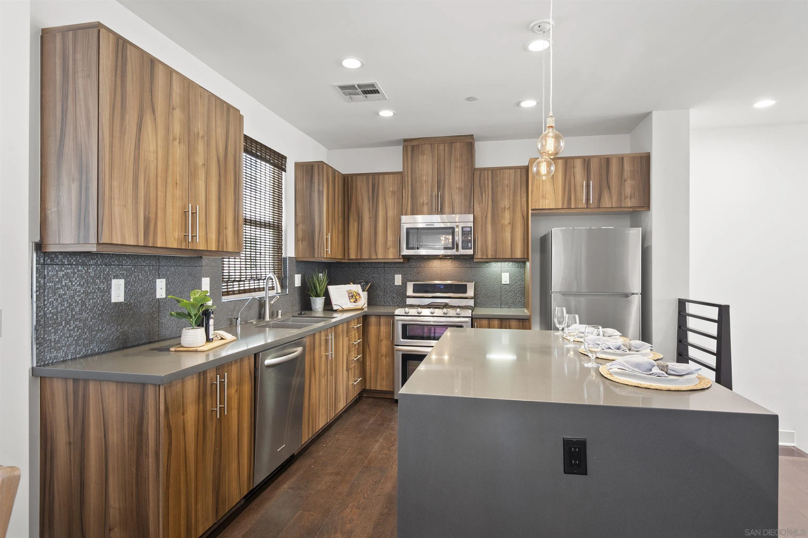 7853 Inception Way San Diego, CA 92108 - Photo 6 of 66 a kitchen with stainless steel appliances a sink a stove a refrigerator cabinets and a center island
