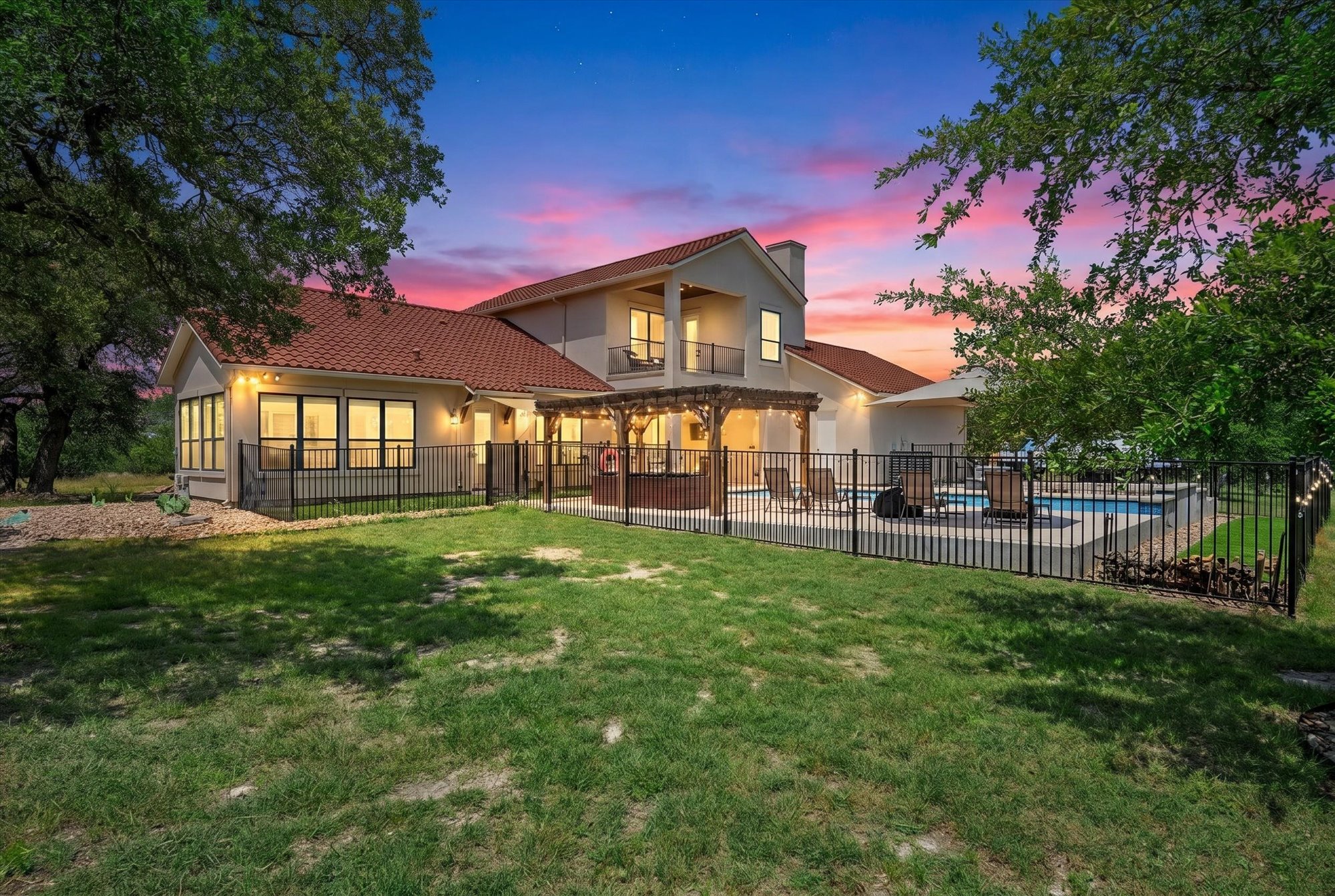 638 Strada Luca Florence, TX 76527 - Photo 3 of 38 A spacious backyard with an inviting pool area, perfect for entertaining under a vibrant twilight sky.