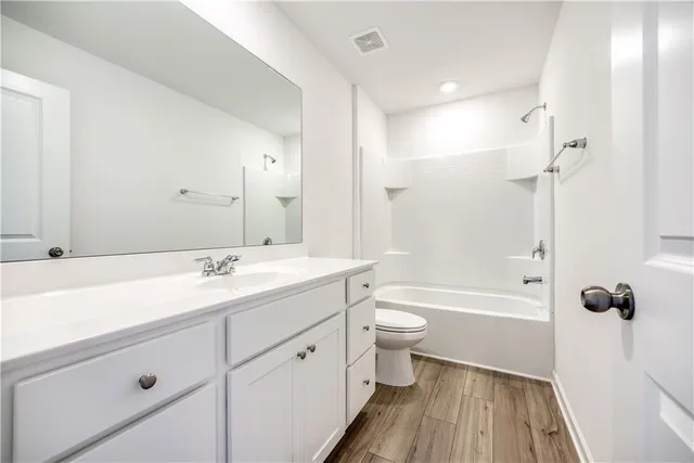 a bathroom with a double vanity sink toilet mirror and shower