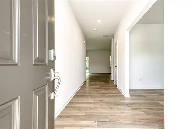a view of a hallway with wooden floor and staircase