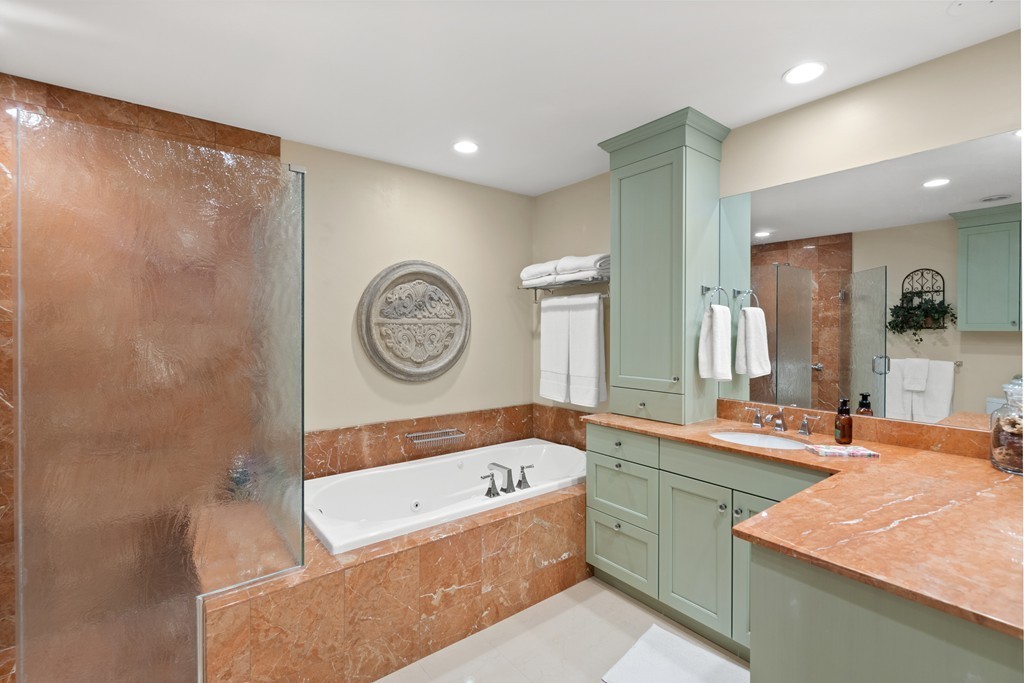 21 South Cottage Road, Unit 21 Belmont, MA 02478 - Photo 17 of 27 a large bathroom with a sink a large mirror and a bathtub with a sink