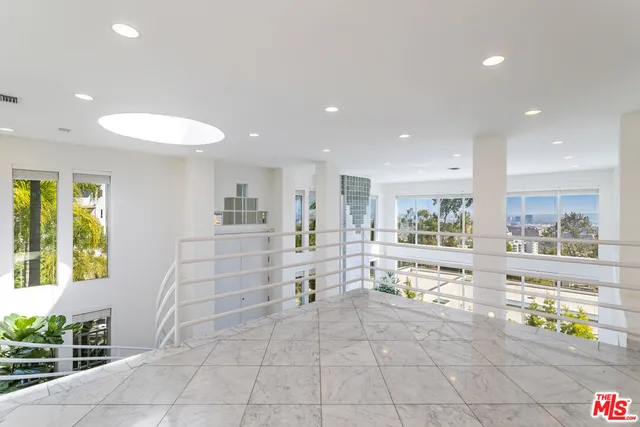 a view of a hallway with dining area and chandelier