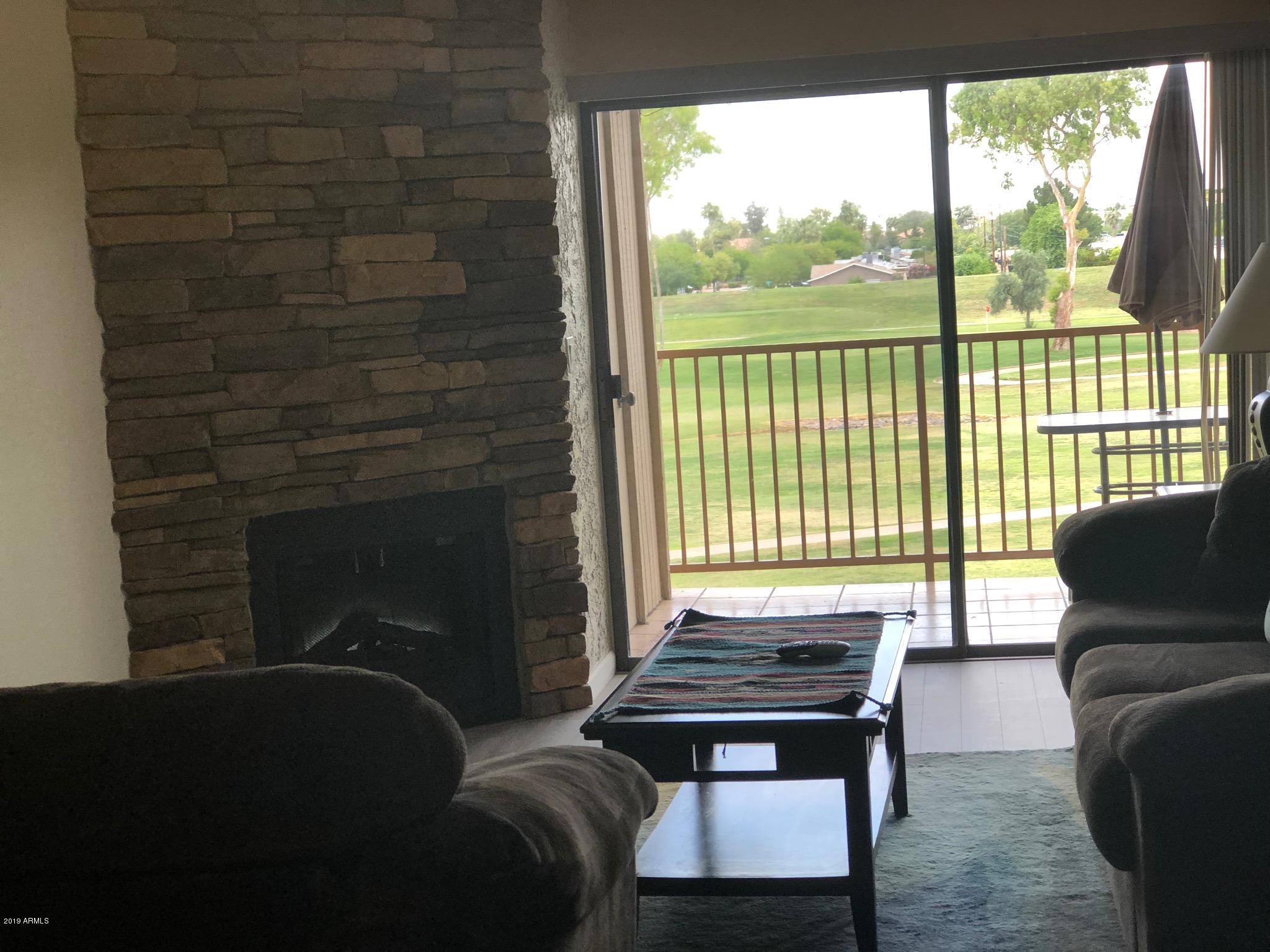 7910 East Thomas Road, Unit 226 Scottsdale, AZ 85251 - Photo 14 of 18 a living room with furniture and a fireplace