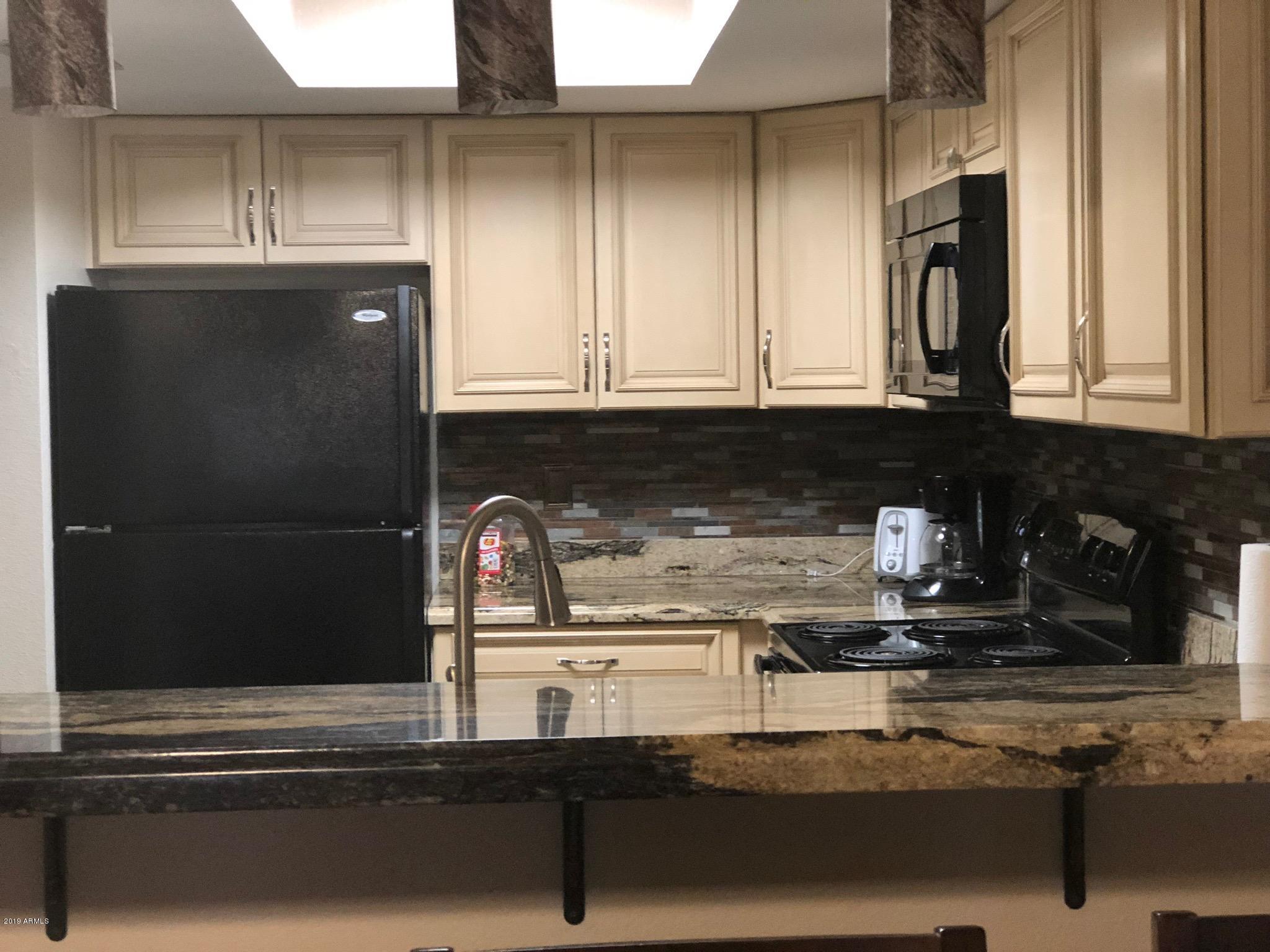 7910 East Thomas Road, Unit 226 Scottsdale, AZ 85251 - Photo 5 of 18 a kitchen with granite countertop a refrigerator and a stove