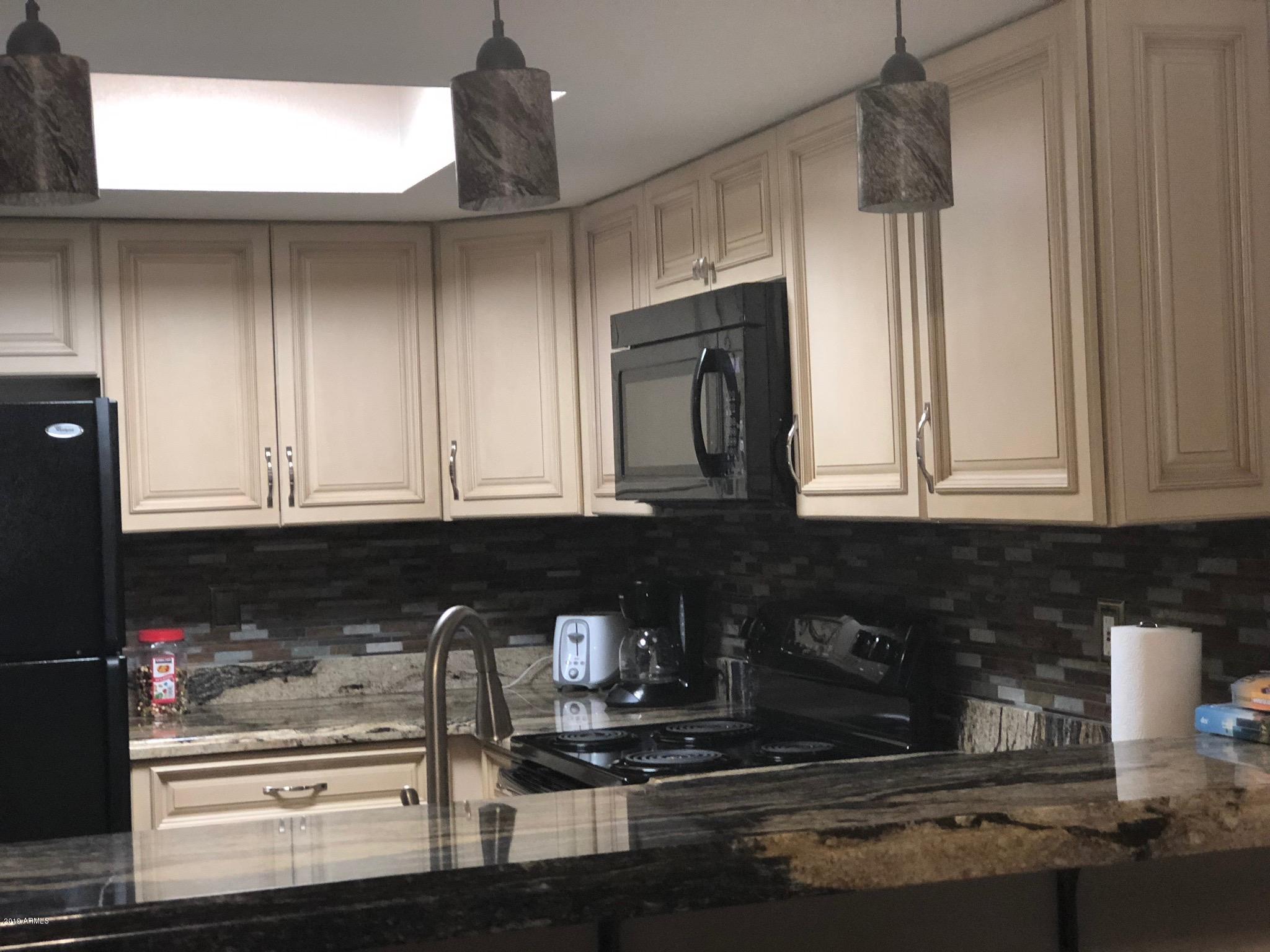 7910 East Thomas Road, Unit 226 Scottsdale, AZ 85251 - Photo 6 of 18 a kitchen with granite countertop a refrigerator and a stove