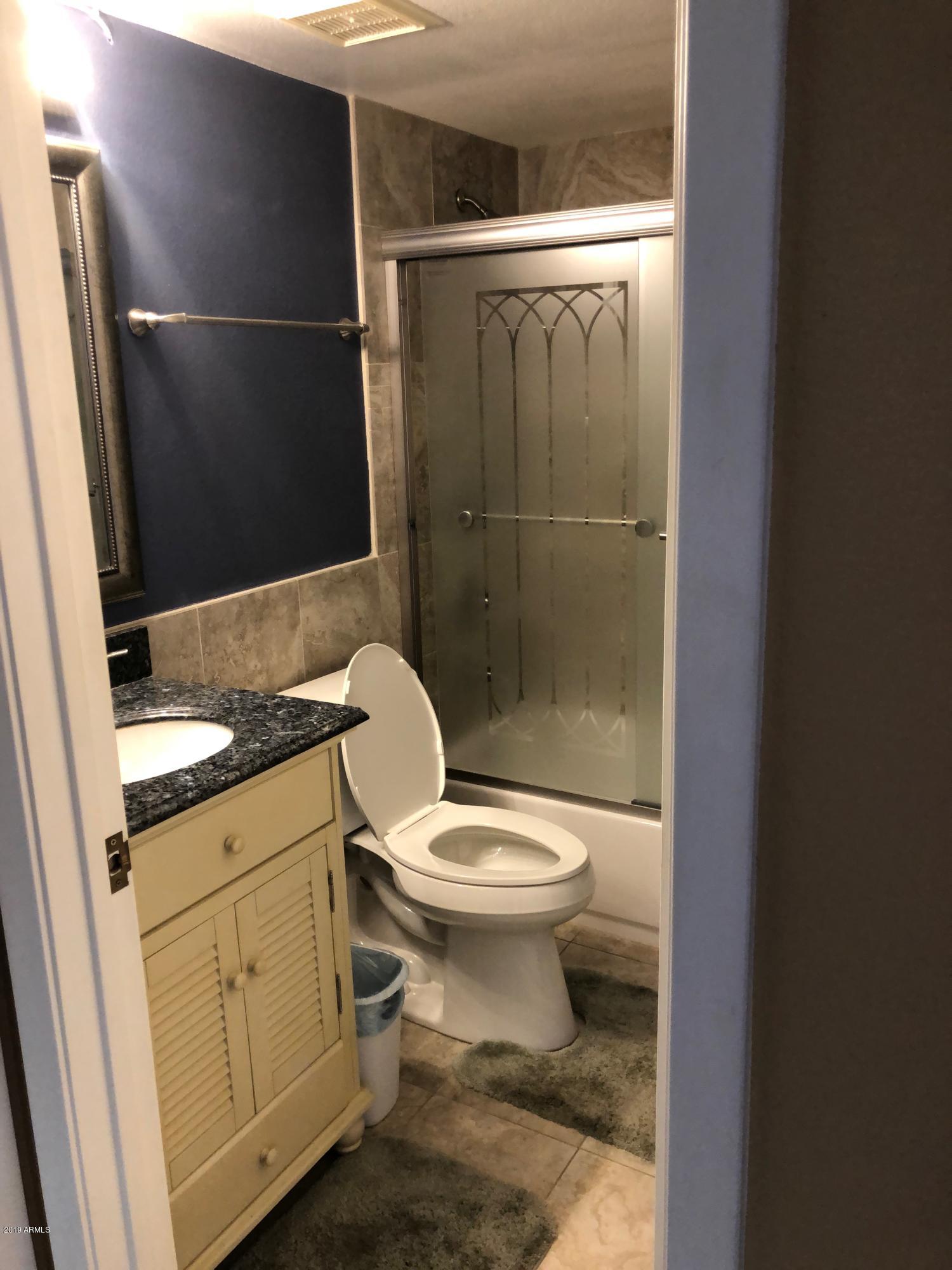 7910 East Thomas Road, Unit 226 Scottsdale, AZ 85251 - Photo 8 of 18 a bathroom with a granite countertop toilet a sink and a mirror