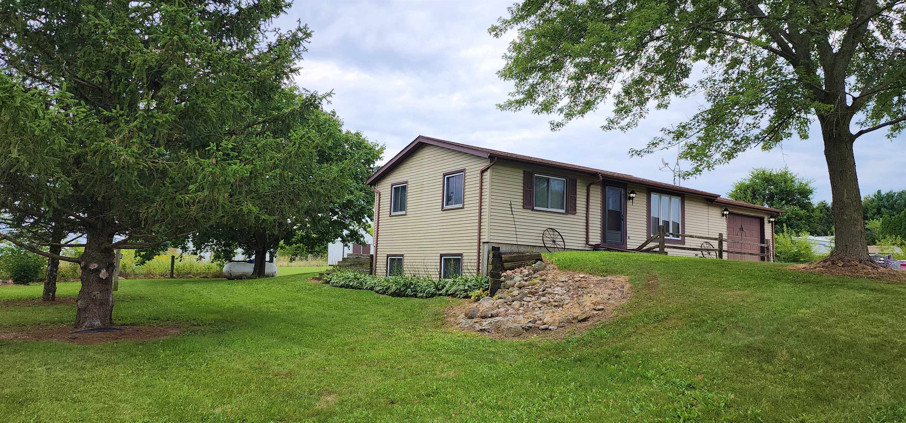 3443 Eddie Road Winnebago, IL 61088 - Photo 1 of 29 a view of a house with a big yard and large trees