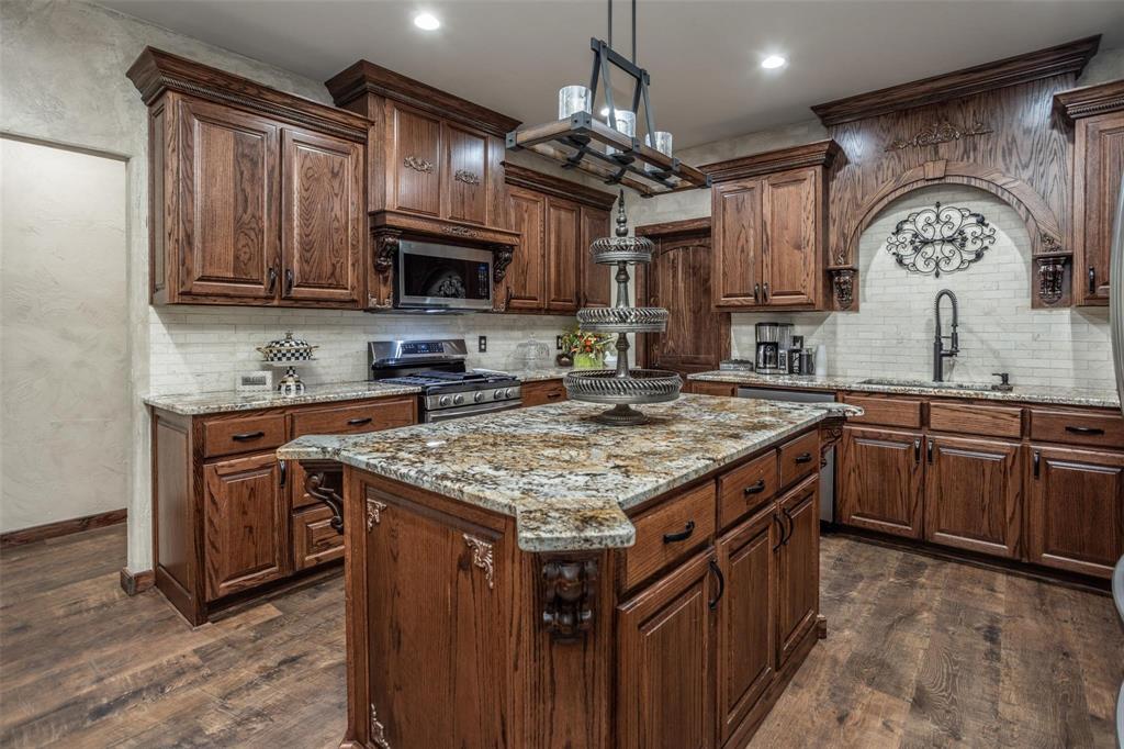 240 Magnolia Lane Bennington, OK 74723 - Photo 12 of 39 a kitchen with stainless steel appliances granite countertop a sink stove and cabinets