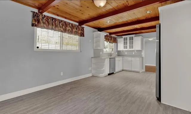 a view of empty room with wooden floor and windows