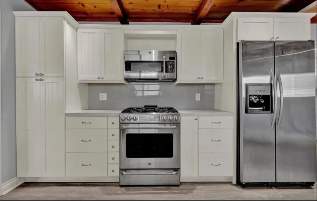 a kitchen with stainless steel appliances white cabinets and a refrigerator