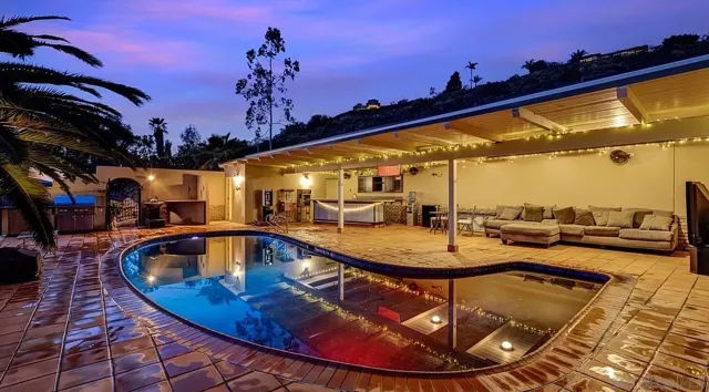 a view of a swimming pool with seating space and furniture