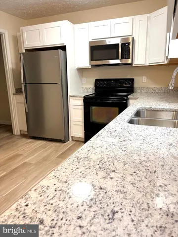 a kitchen with stainless steel appliances a refrigerator a stove a microwave and cabinets