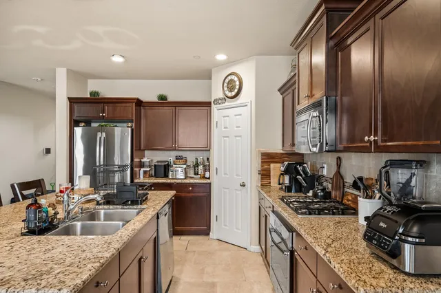 a kitchen with granite countertop a sink stove and cabinets