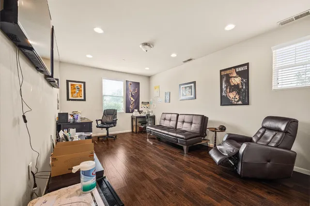 a living room with furniture and a wooden floor