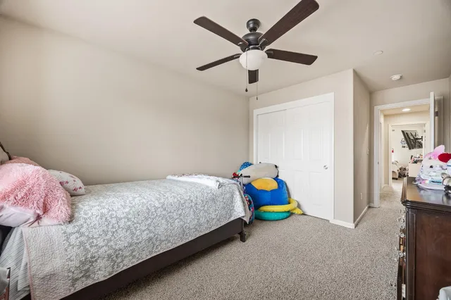 a bedroom with a bed a dresser and a chandelier