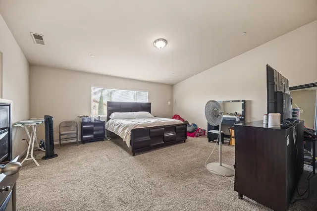 a spacious bedroom with a bed and a desk in it