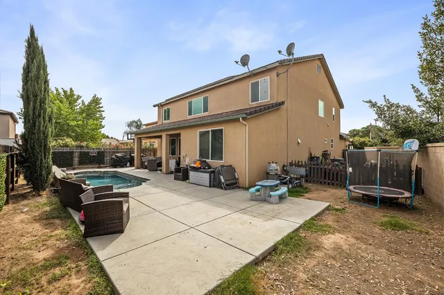 a view of a backyard with furniture and a grill
