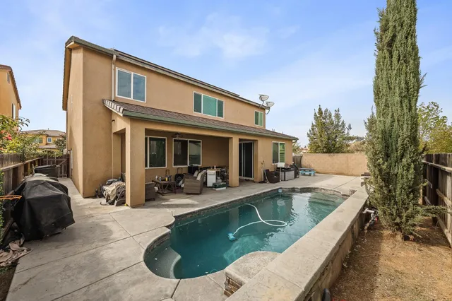 a view of a house with swimming pool and sitting area