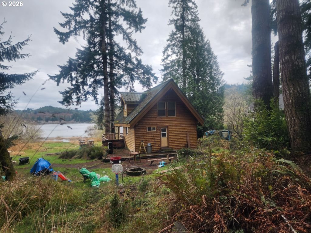 3117 South Tenmile Lakeside, OR 97449 - Photo 1 of 33 a view of backyard with plants and large trees