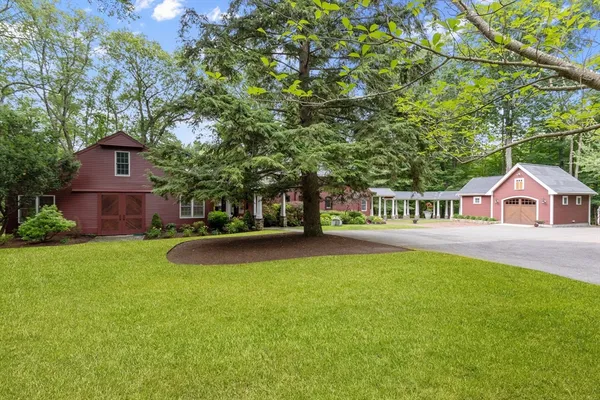 a view of a house with a yard and a large tree