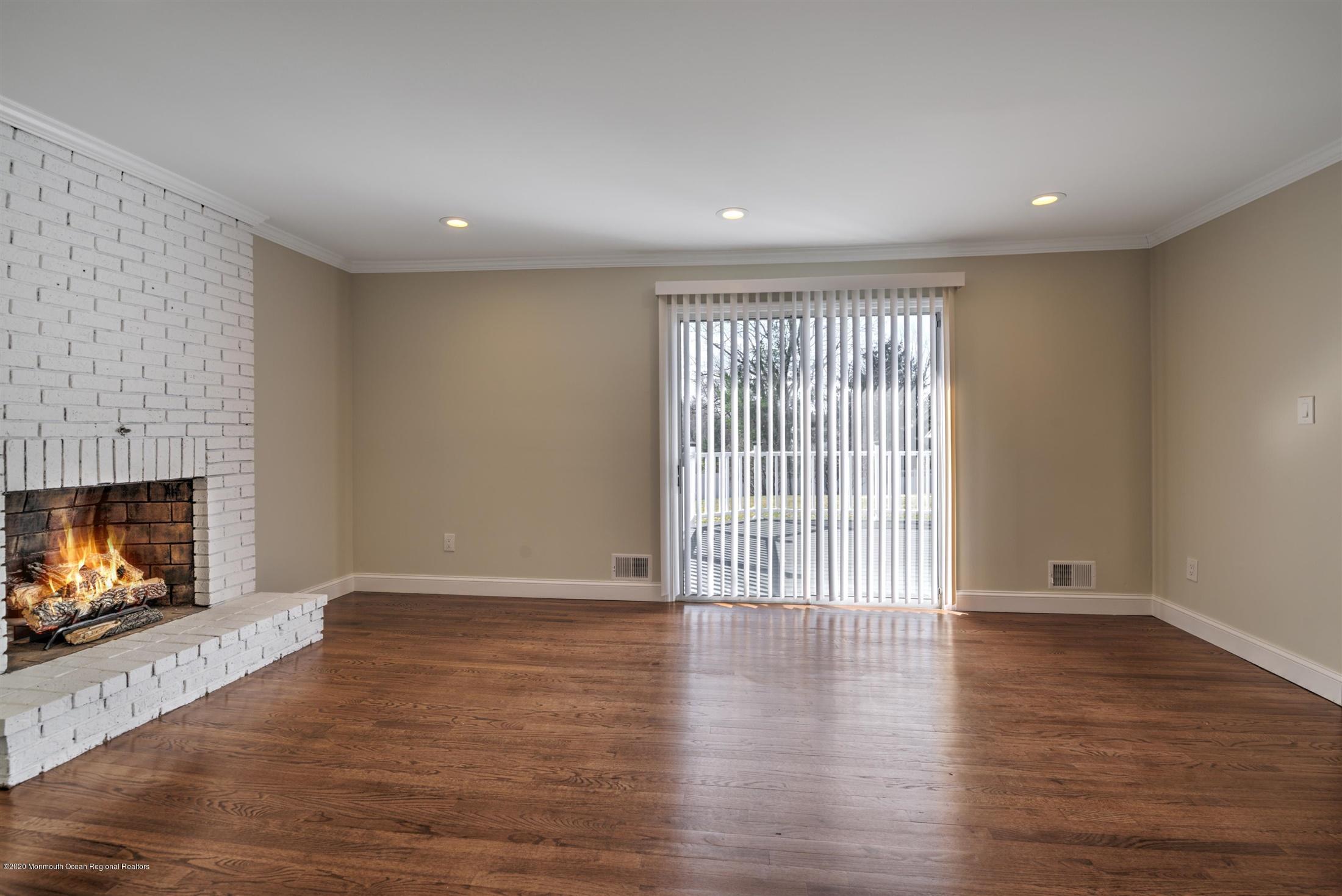 518 East Freehold Road Freehold, NJ 07728 - Photo 14 of 35 a view of an empty room with wooden floor and fireplace