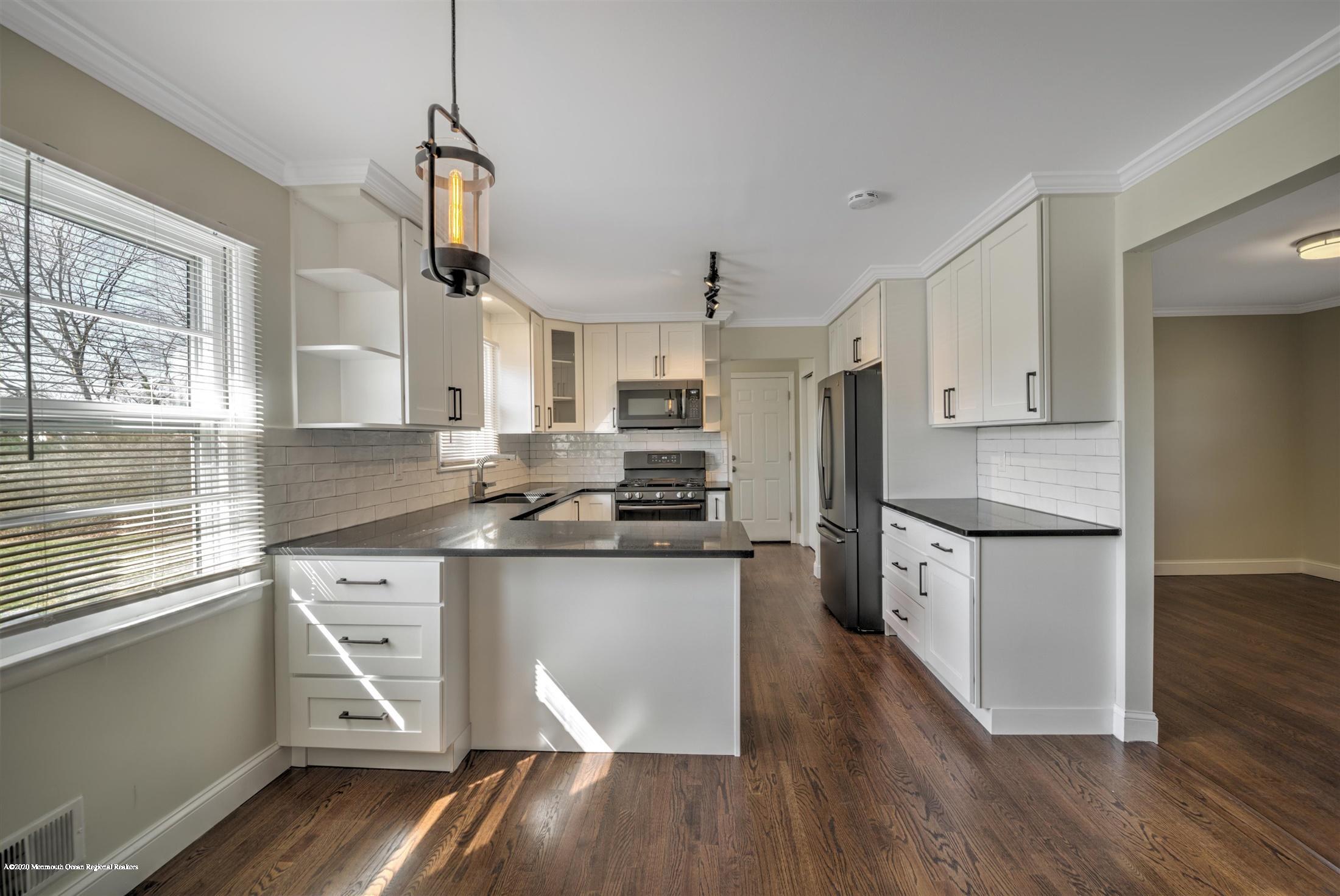 518 East Freehold Road Freehold, NJ 07728 - Photo 2 of 35 a kitchen with stainless steel appliances granite countertop a refrigerator a stove top oven a sink dishwasher and white cabinets with wooden floor