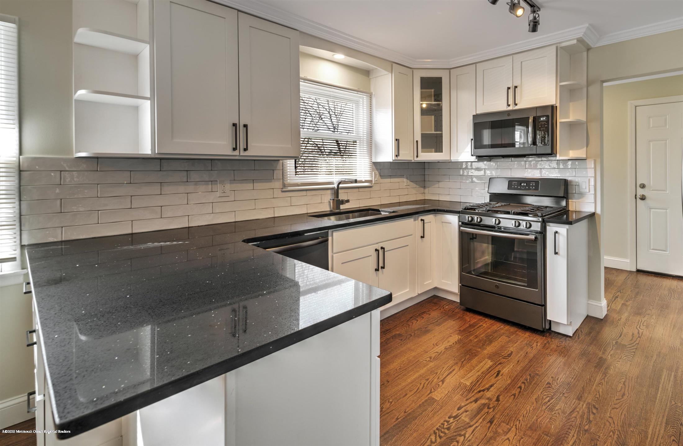 518 East Freehold Road Freehold, NJ 07728 - Photo 3 of 35 a kitchen with granite countertop a stove and a microwave