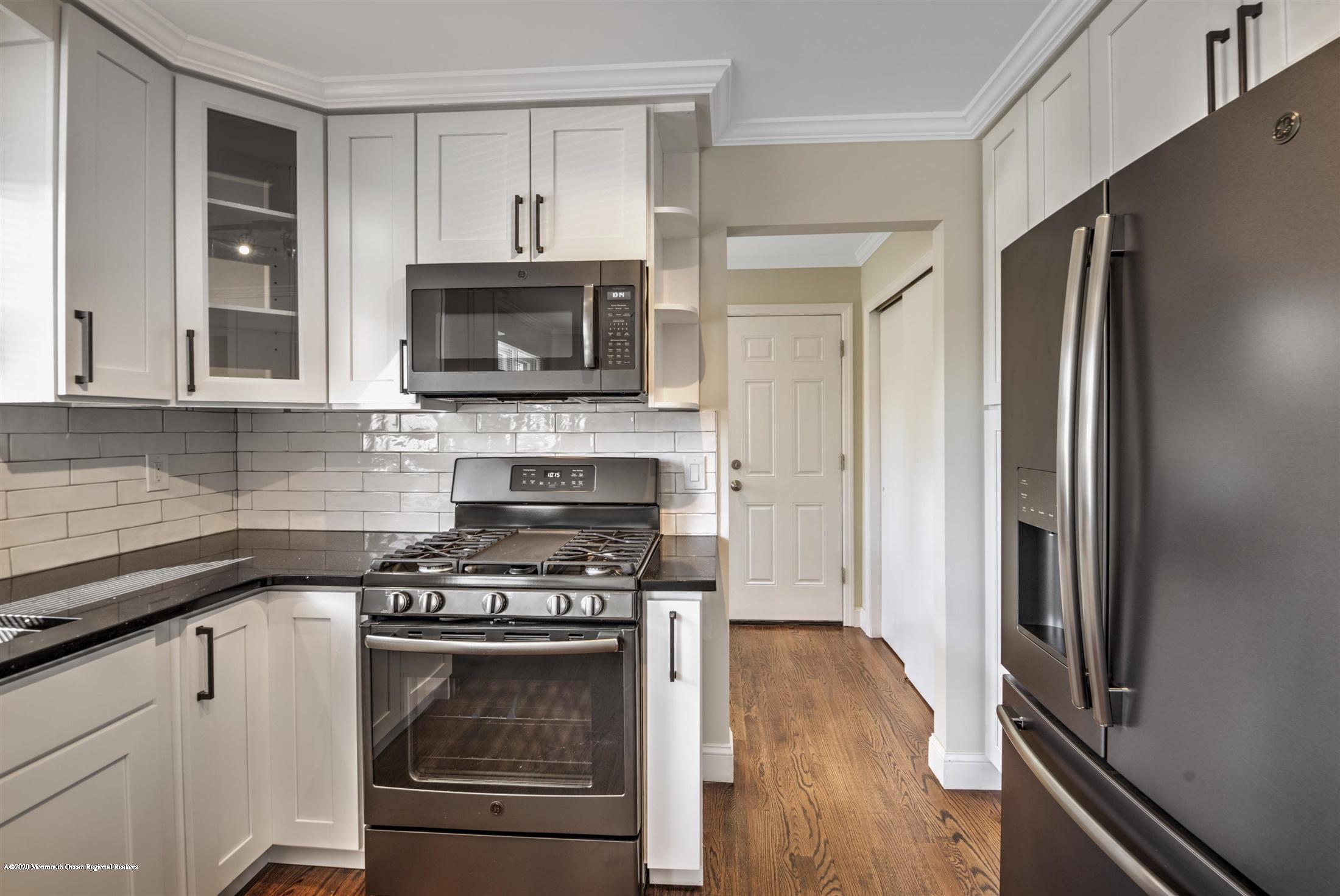 518 East Freehold Road Freehold, NJ 07728 - Photo 6 of 35 a kitchen with a stove and a microwave
