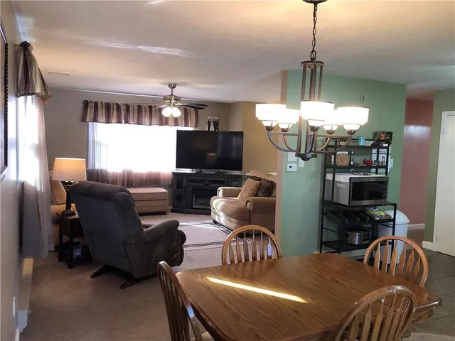 a dining room with furniture a chandelier and window