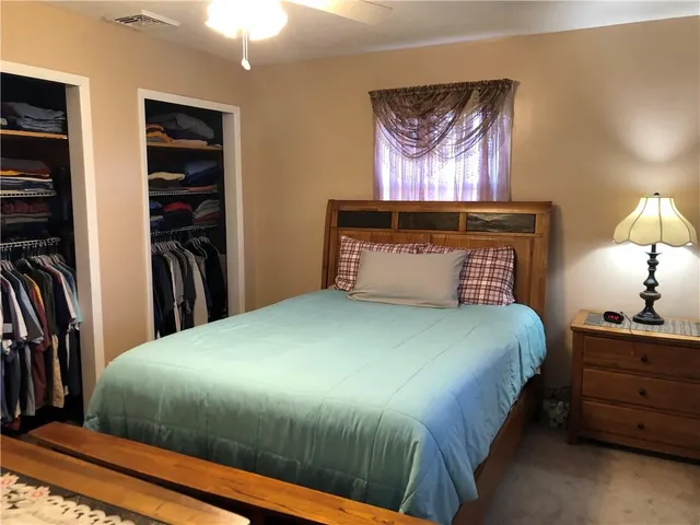 a bedroom with a bed and a lamp on dresser