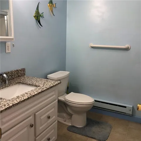 a bathroom with a granite countertop toilet and a sink