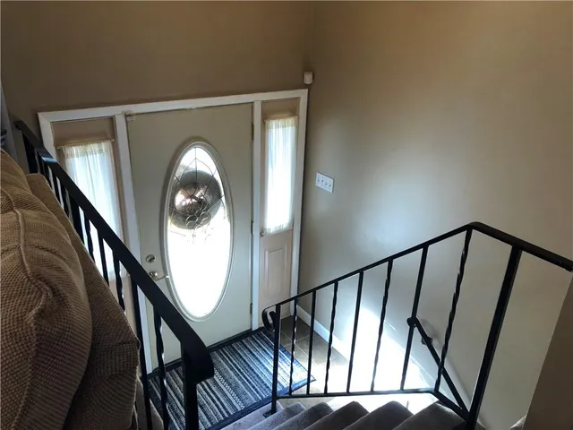 a view of staircase with railing and white walls