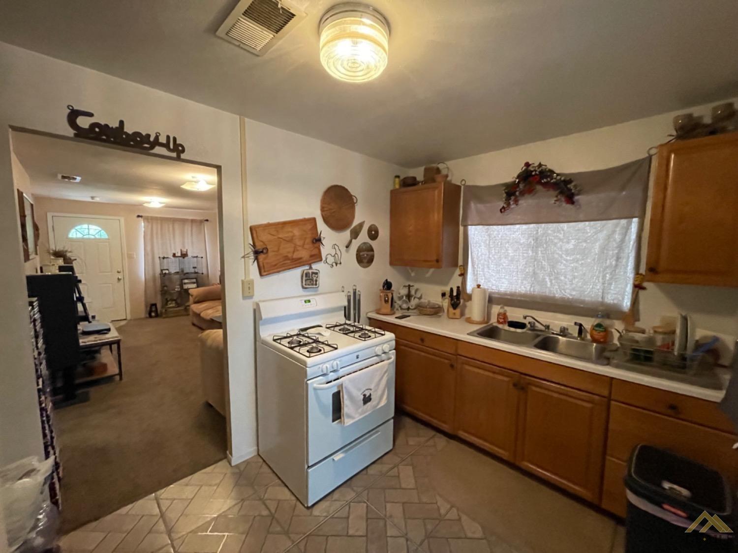 Undisclosed Address Taft, CA 93268 - Photo 11 of 17 a kitchen with a sink stove and cabinets